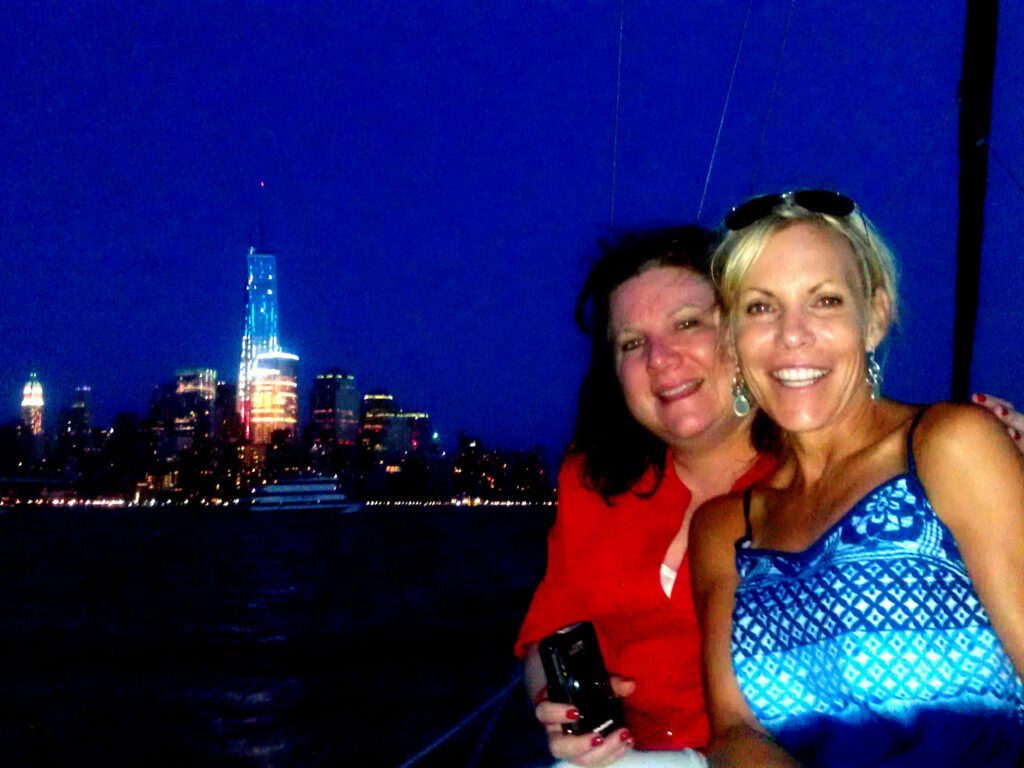 Two women and the NYC skyline during the City Lights Sailing Tour
