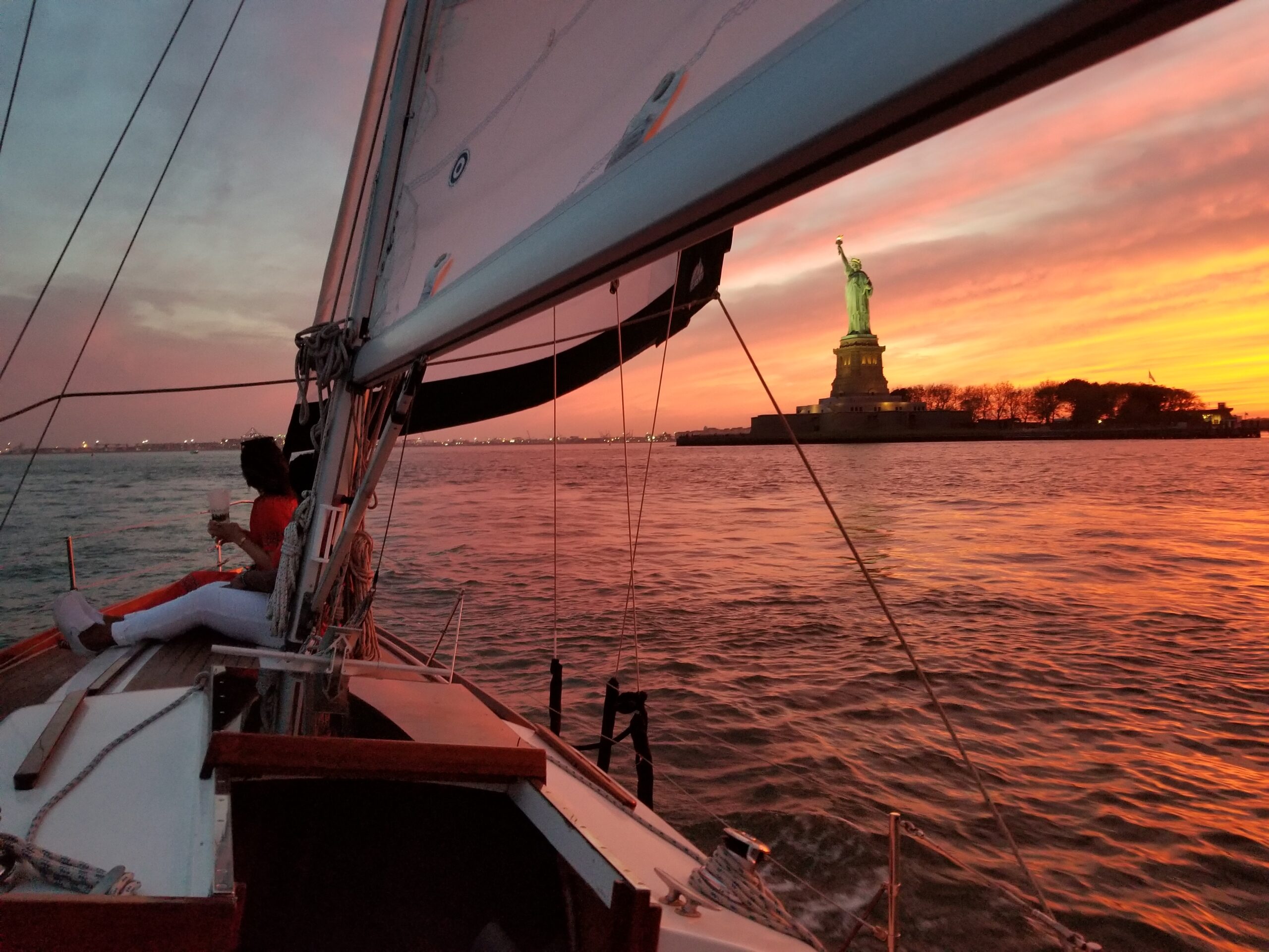 ship sailing with new rok city in the background during the day