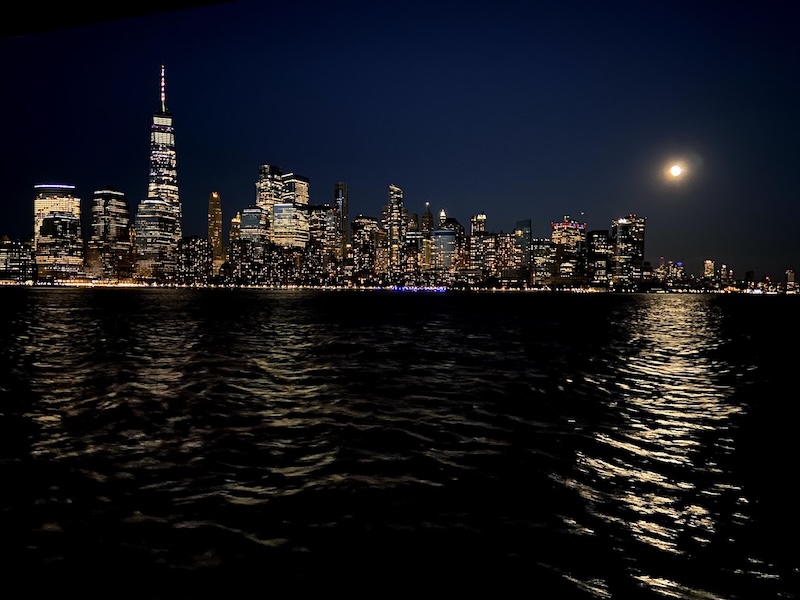 ship sailing with new rok city in the background during the day